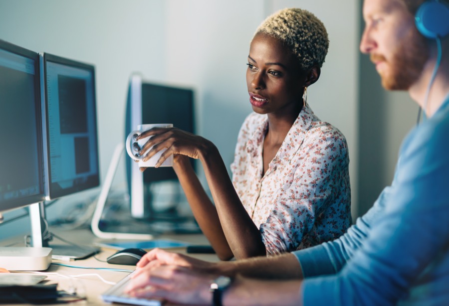 Two colleagues working together at a workstation